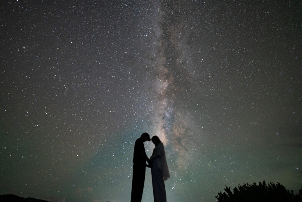 天の川と向かい合うシルエットの二人