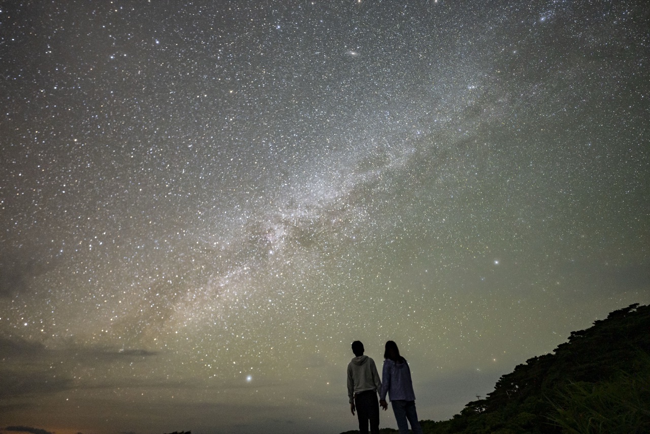 Couple milky way watching landscape at Nagareboshi no Oka stargazing spot, Ishigaki Island