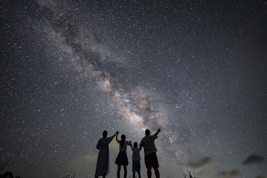 Family four silhouette milky way at Nagareboshi no Oka stargazing spot, Ishigaki Island